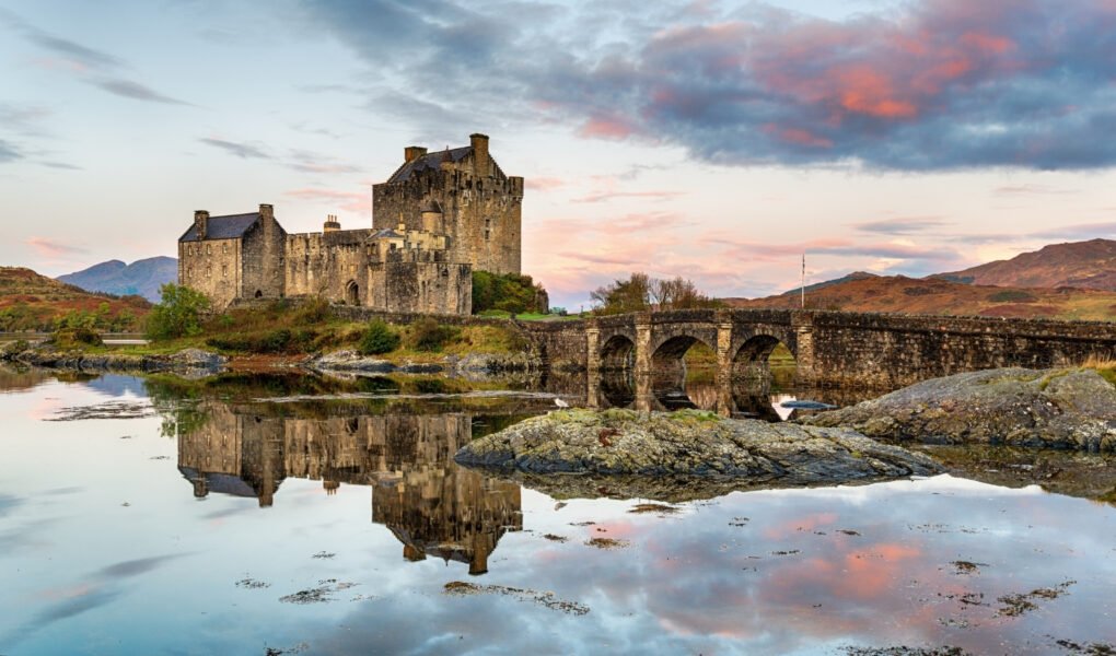 Eilean Donan Castle reflected on calm sea at sunset