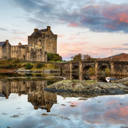 Eilean Donan Castle reflected on calm sea at sunset