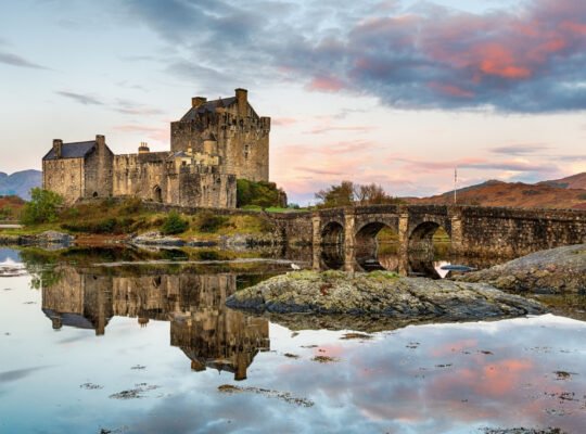 Eilean Donan Castle reflected on calm sea at sunset