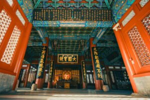 Interior view of Forbidden City hall with intricate painted ceiling and red columns