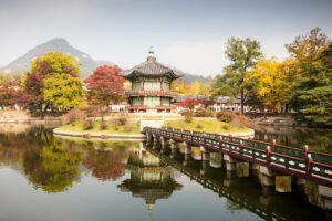 Hyangwonjeong pavilion on island pond with bridge at Gyeongbokgung Palace in autumn
