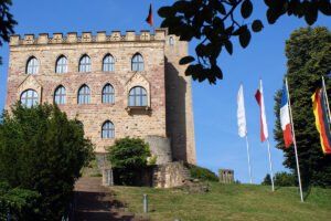 View of Hambach Castle façade and flags on hill