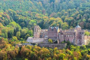 Heidelberg Castle set against wooded hillside in autumn