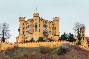 Hohenschwangau Castle exterior on hill with yellow facade and crenellated walls