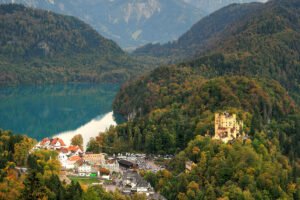 Hohenschwangau Castle on forested hill above turquoise lake