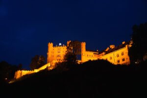 Hohenschwangau Castle illuminated against deep blue night sky