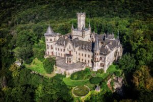 Aerial view of Marienburg Castle surrounded by dense forest