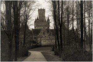 Marienburg Castle seen through leafless trees along winding path