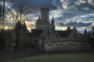 Castle in the Clouds silhouette against dramatic cloudy sunset sky