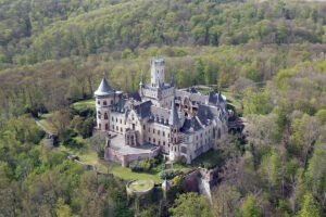 Aerial view of Marienburg Castle among forested hills