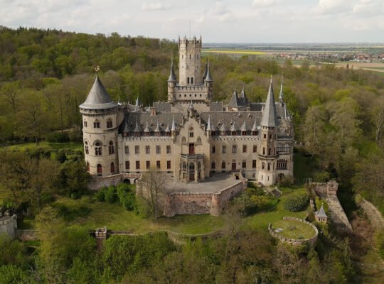 Aerial view of Marienburg Castle surrounded by forest