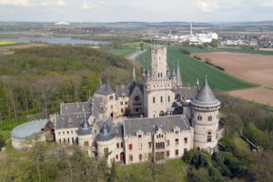 Aerial view of Marienburg Castle surrounded by forest and farmland