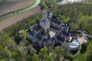 Aerial view of Marienburg Castle surrounded by forest and river