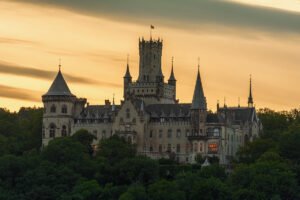 Marienburg Castle silhouette above forest at sunset