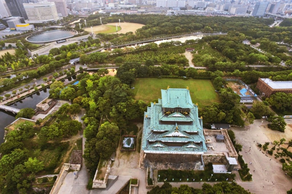 Aerial view of Osaka Castle with surrounding park and moat