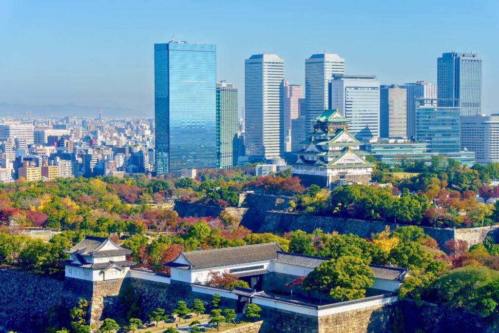 Osaka Castle with city skyline and autumn trees