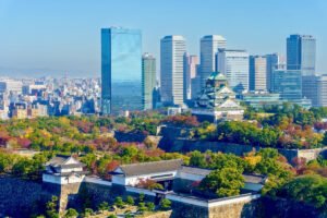 Osaka Castle with city skyline and autumn trees