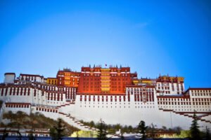 Potala Palace illuminated on Lhasa hill against deep blue sky