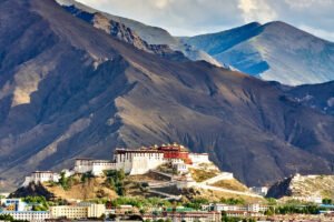 Potala Palace framed by rugged Himalayan mountains above Lhasa city