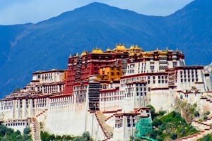 Potala Palace perched on hill with white walls and golden rooftops