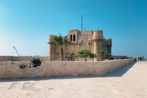 Qaitbay Citadel fortress by the sea under clear blue sky