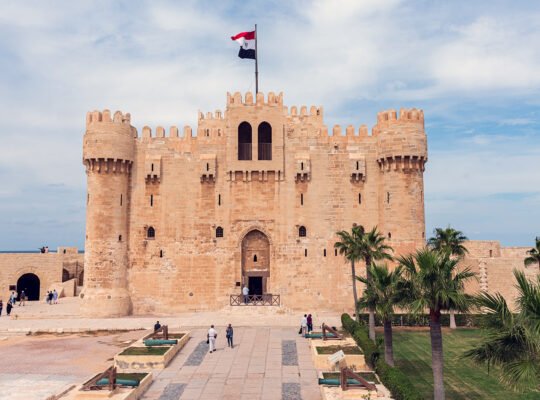 Front view of Qaitbay Citadel fortress by the Mediterranean with Egyptian flag