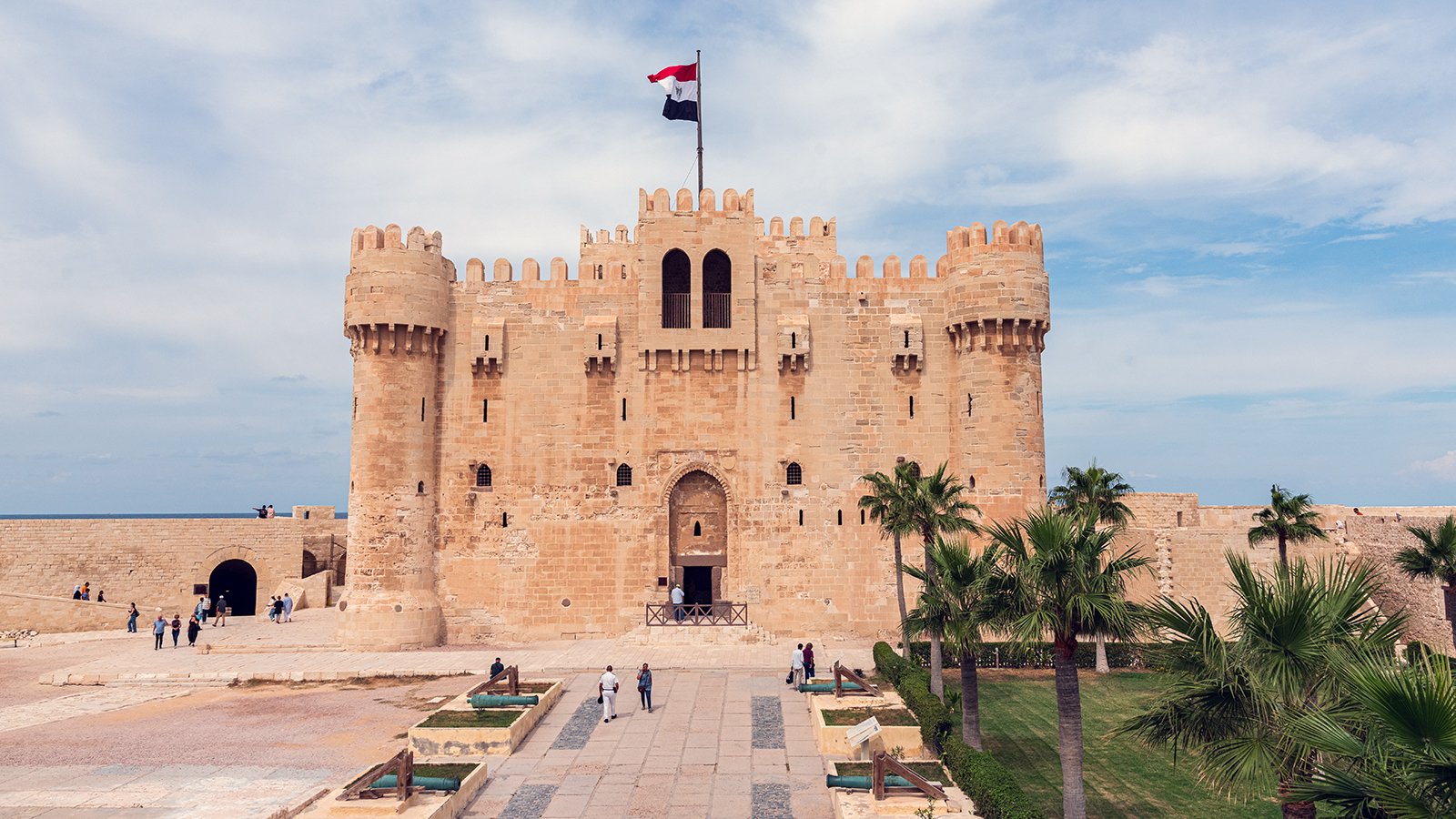 Front view of Qaitbay Citadel fortress by the Mediterranean with Egyptian flag