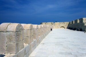 Stone battlements and sea terrace at Qaitbay Citadel under deep blue sky