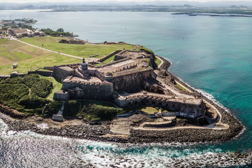 Aerial view of Castillo San Felipe del Morro perched on rocky coastline, turquoise Atlantic waters