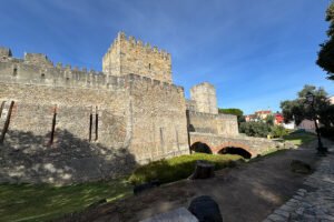 Fortified walls and towers of São Jorge Castle against blue sky