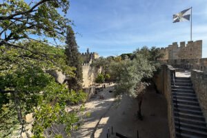 View of São Jorge Castle battlements and courtyard framed by trees