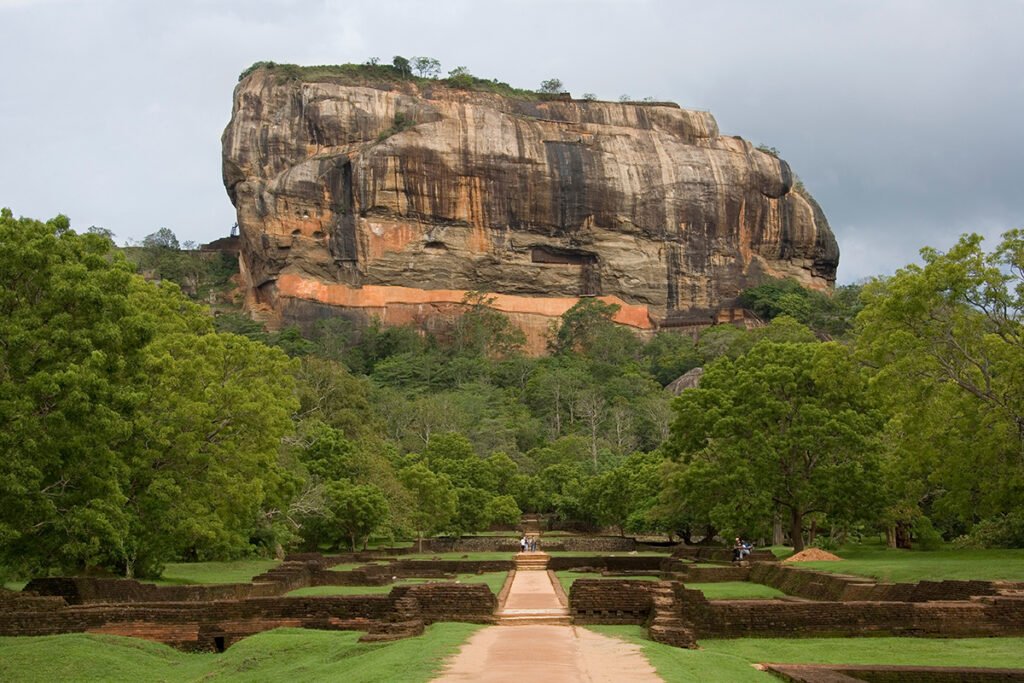 Sigiriya rock fortress rising above lush green gardens and ancient ruins