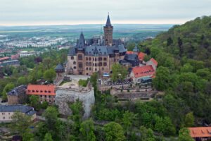 Aerial view of Wernigerode Castle atop wooded hill