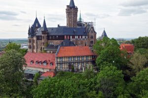 Wernigerode Castle perched above timbered houses and lush green trees