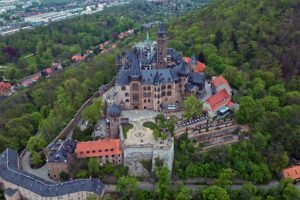 Aerial view of Wernigerode Castle atop wooded hill