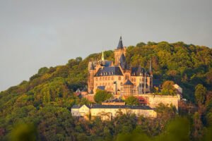 Wernigerode Castle on forested hill at sunset