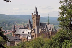 Wernigerode Castle perched above forest with Harz hills and village backdrop