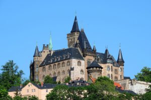 Wernigerode Castle on hill with towers against blue sky