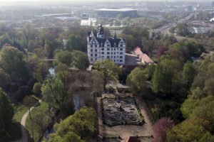 Aerial view of Wolfsburg Castle surrounded by formal gardens and parkland