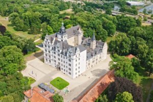 Aerial view of Wolfsburg Castle surrounded by green parkland