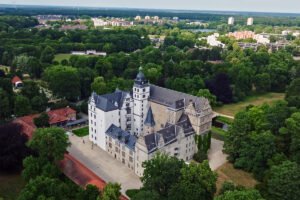 Aerial view of Wolfsburg Castle among green parkland