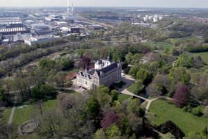 Aerial view of Wolfsburg Castle surrounded by parkland and industrial skyline
