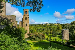 Blarney Castle tower and lush gardens under blue sky