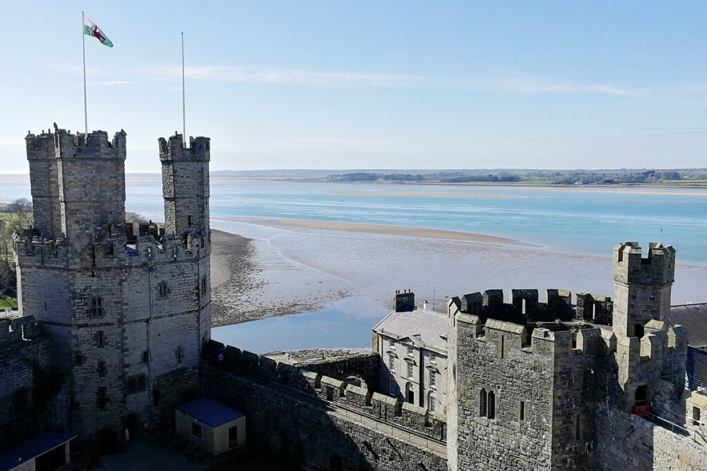 Aerial view of Caernarfon Castle and estuary under clear sky