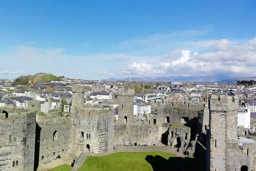 Aerial view of Caernarfon Castle and town under clear sky