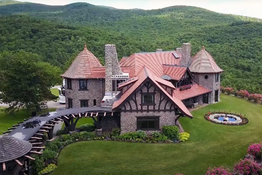 Aerial view of Castle in the Clouds estate amid green mountain ridges