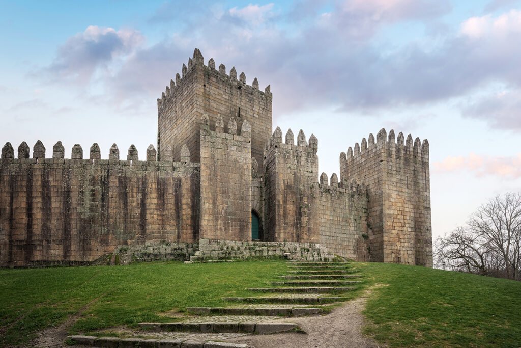 Castle of Guimaraes stone towers and battlements against pastel sky