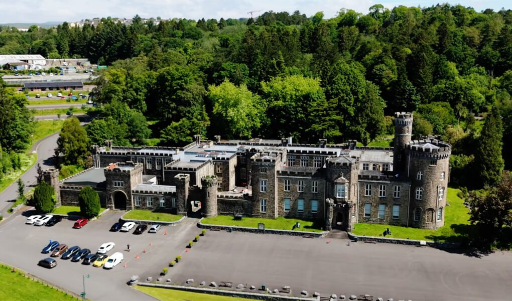 Aerial view of Cyfarthfa Castle amid woodland and parking area