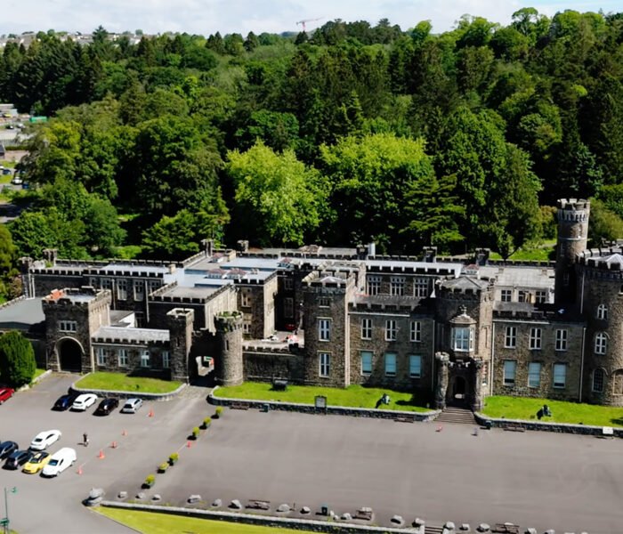 Aerial view of Cyfarthfa Castle amid woodland and parking area