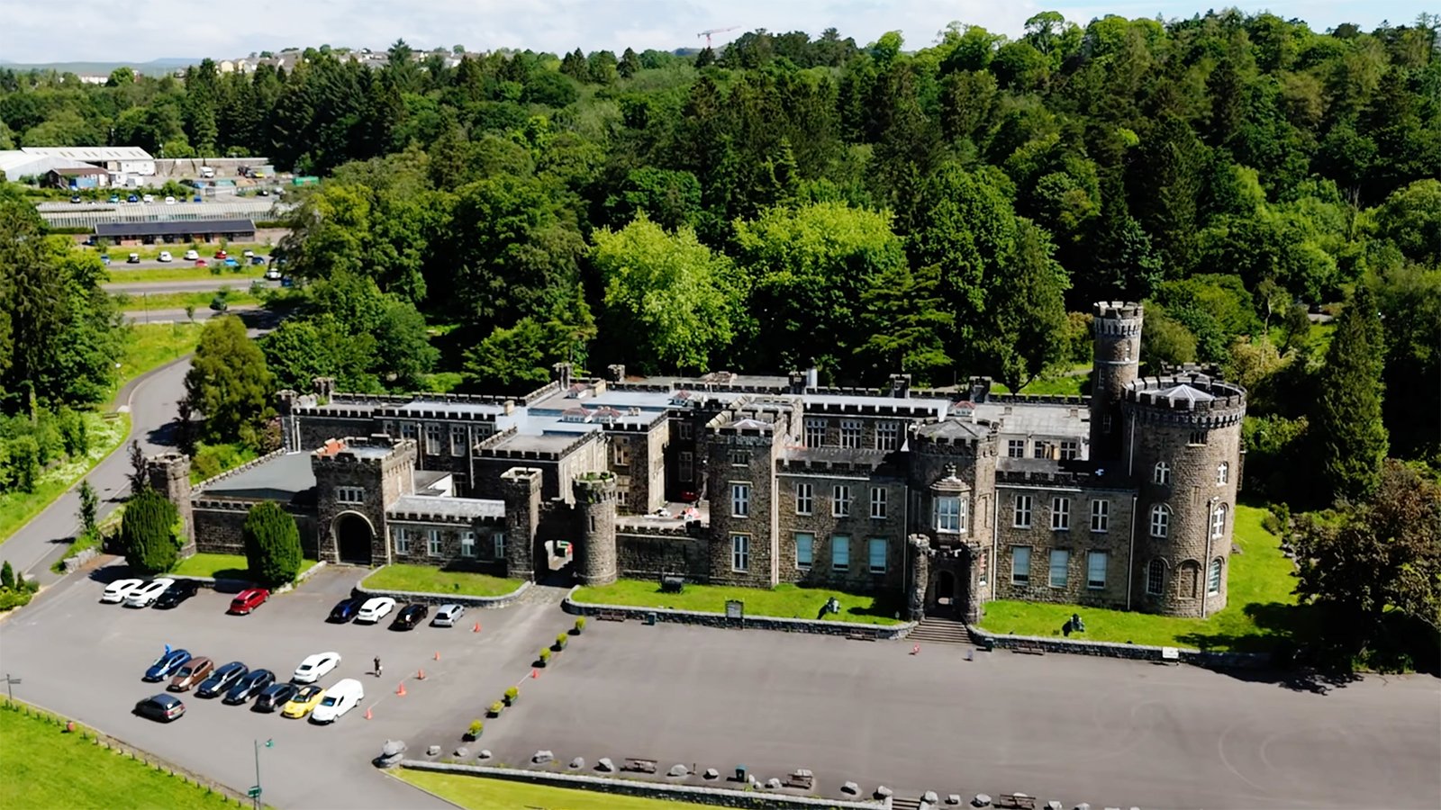 Aerial view of Cyfarthfa Castle amid woodland and parking area
